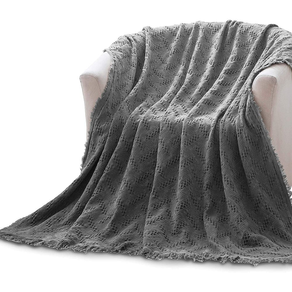 Kasentex gray knitted cotton throw blanket with fringe edges draped over a sofa on Tampa Home & Garden Store