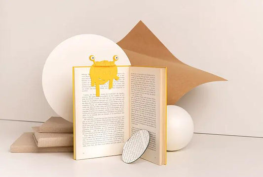 Spaghetti Tale Bookmark OTOTO Edition by OTOTO DESIGN yellow character perched on book on Tampa Home & Garden Store
