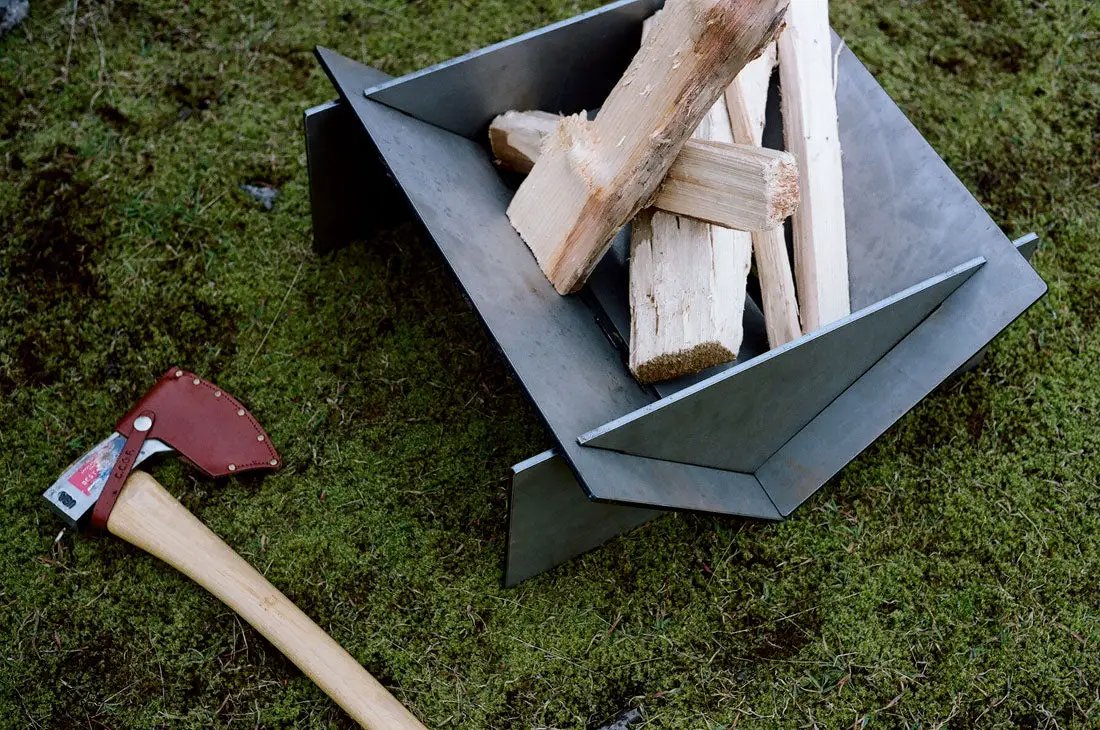 Stahl Patio Firepit steel angular design with firewood in pit, red-handled axe nearby on Tampa Home & Garden Store