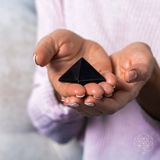Conscious Items shungite pyramid held in cupped hands, black home decor stone on Tampa Home & Garden Store