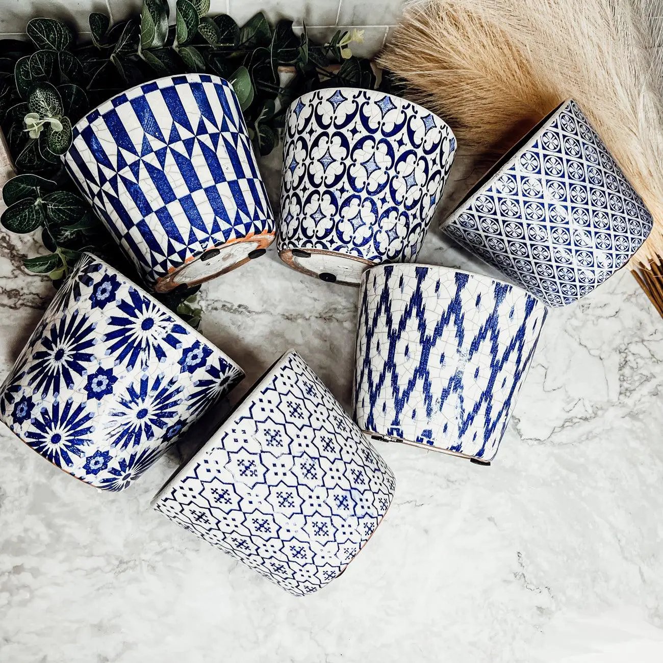 Ceramic pots in blue and white with geometric and floral patterns, six pieces on marble on Tampa Home & Garden Store