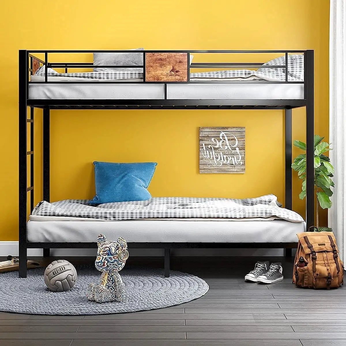 Twin over twin black metal bunk bed with two bunks, pillow against yellow wall on Tampa Home & Garden Store