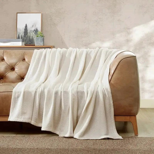 Twin-size Cream Bone Cotton Blanket, machine washable, draped over a tan leather sofa on Tampa Home & Garden Store