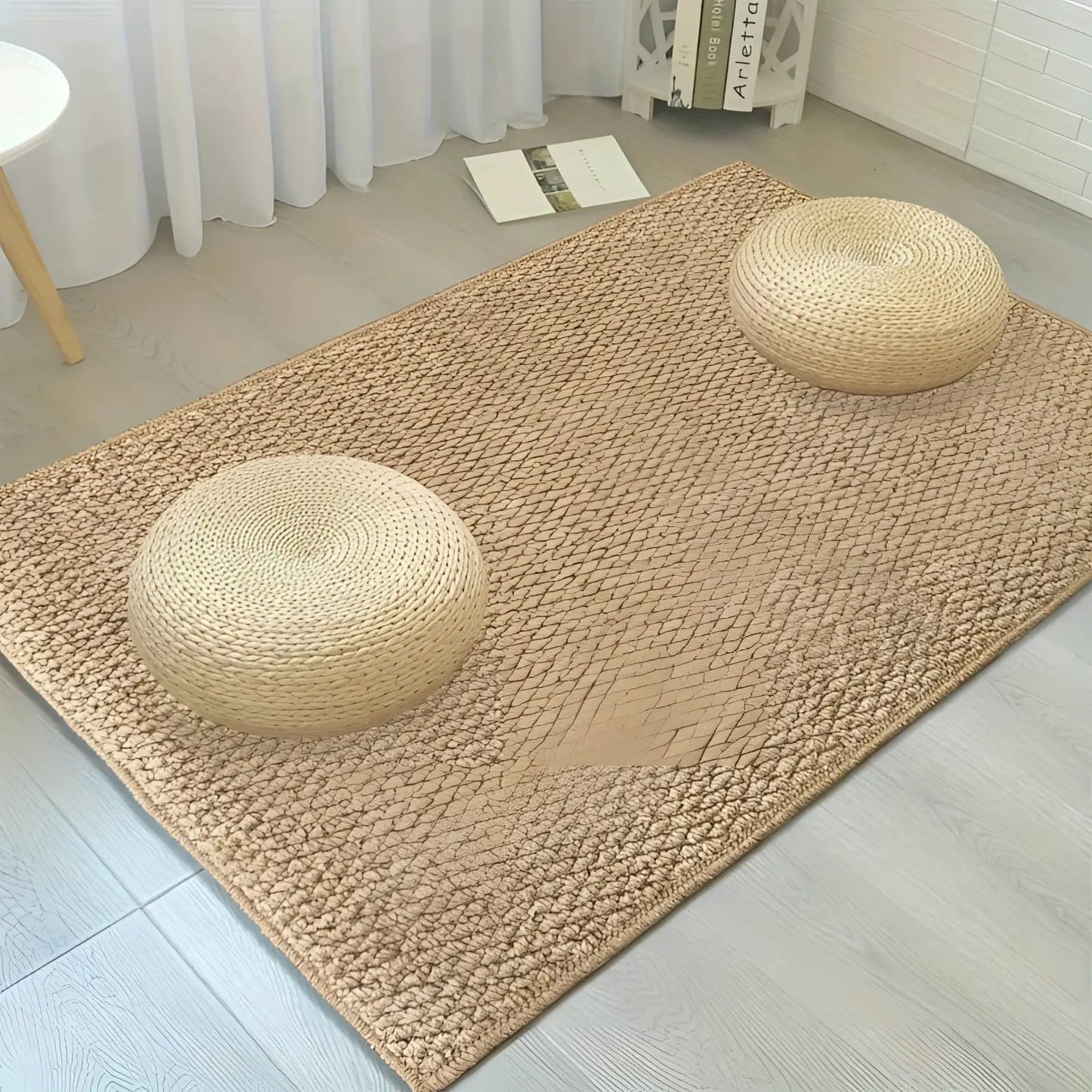 Beige indoor doormat Moktan Sabai with non-slip jute look pattern; two round woven poufs on mat on Tampa Home & Garden Store