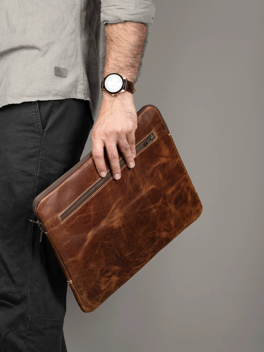 Tan Laptop Sleeve with Secure Zipper Closure, brown leather texture, held by a man in gray shirt on Tampa Home & Garden Store