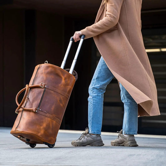 Tan Buffalo Leather Trolley Bag 44L With Wheels rolling duffel on sidewalk on Tampa Home & Garden Store