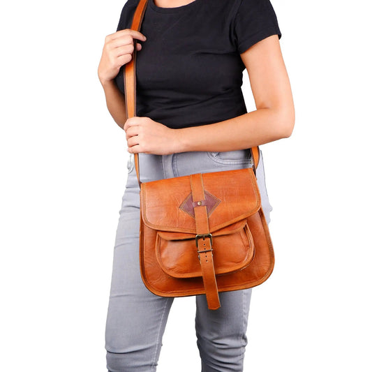 Briggs Satchel Crossbody Bag in warm brown leather with orange-brown strap and front buckle on Tampa Home & Garden Store