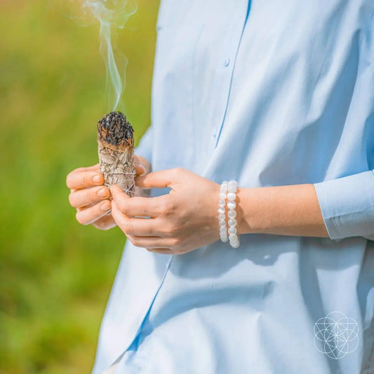Cleansing Selenite Beaded Bracelet with white beads worn on wrist beside a smudge bundle on Tampa Home & Garden Store