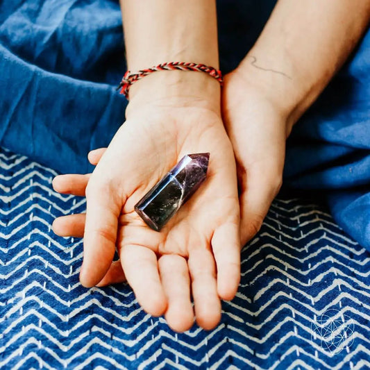 Fluorite cleansing stone point held in hands, purple crystal decor for energy clarity on Tampa Home & Garden Store