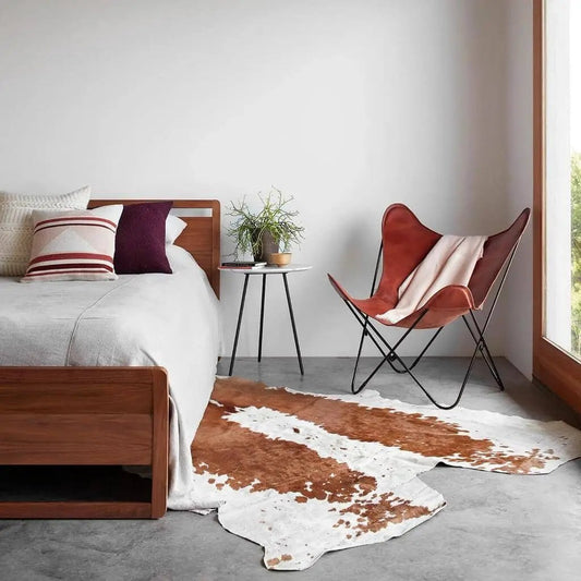 Cognac Vintage Butterfly Chair in tan leather with black metal frame beside a wooden bed on Tampa Home & Garden Store