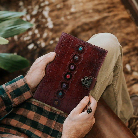 Seven Stone Leather Journal burgundy leather with seven gemstone buttons held by plaid-clad hand on Tampa Home & Garden Store