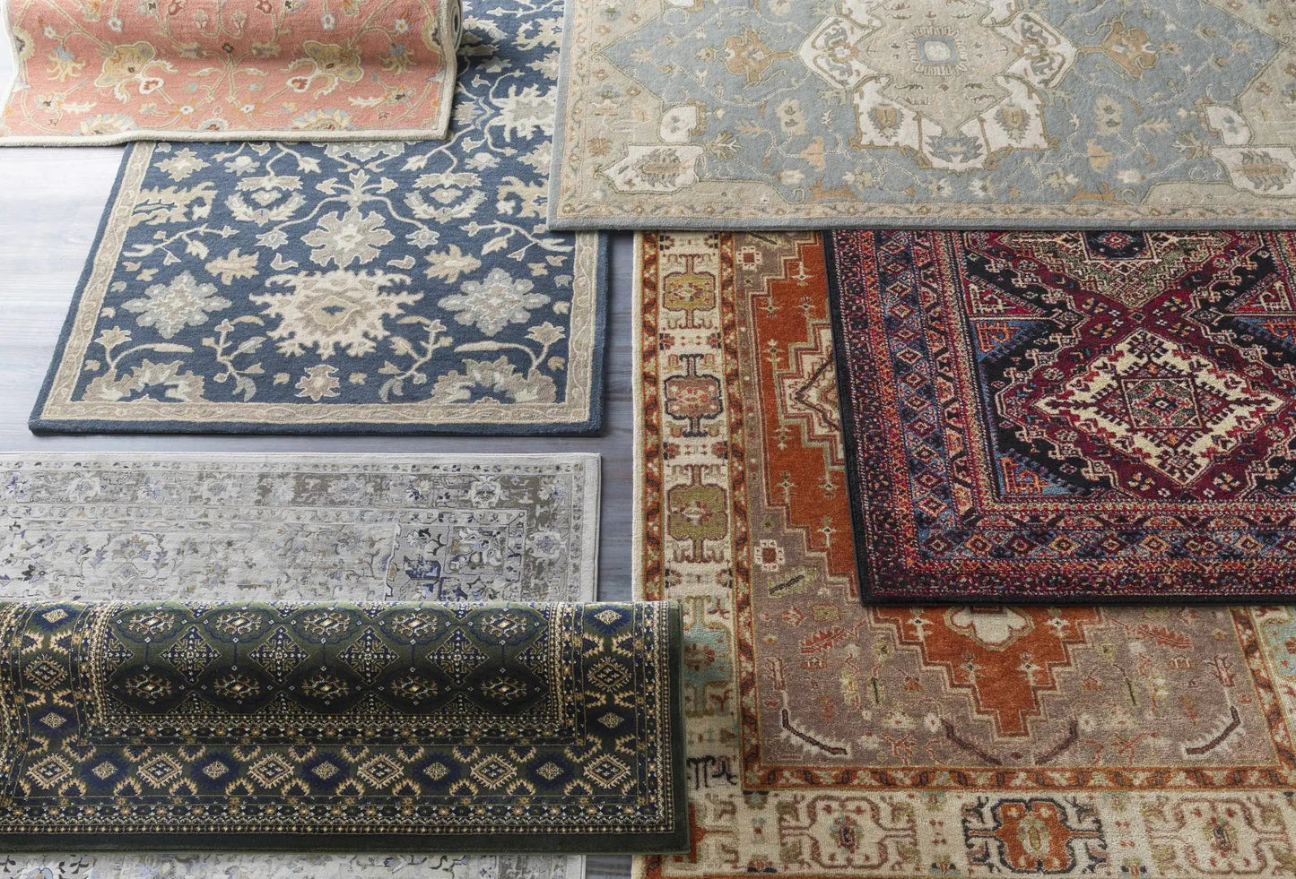 Logville Hand Tufted Wool Rug Jet Black shown among vintage patterned rugs in blue beige and red on Tampa Home & Garden Store