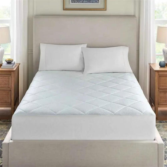 Twin size quilted mattress pad with elastic skirt on white bed in a peaceful bedroom on Tampa Home & Garden Store