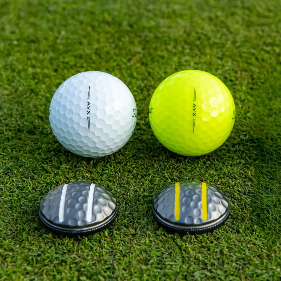 Two Rail 3D Ball Markers for Green Alignment golf markers, black discs with white and yellow rails on grass on Tampa Home & Garden Store