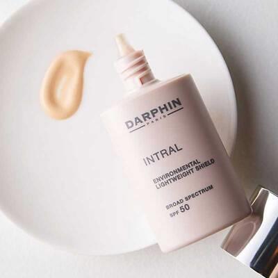 Darphin Intral SPF50 face cream bottle in pale pink with cream swatch on plate on Tampa Home & Garden Store