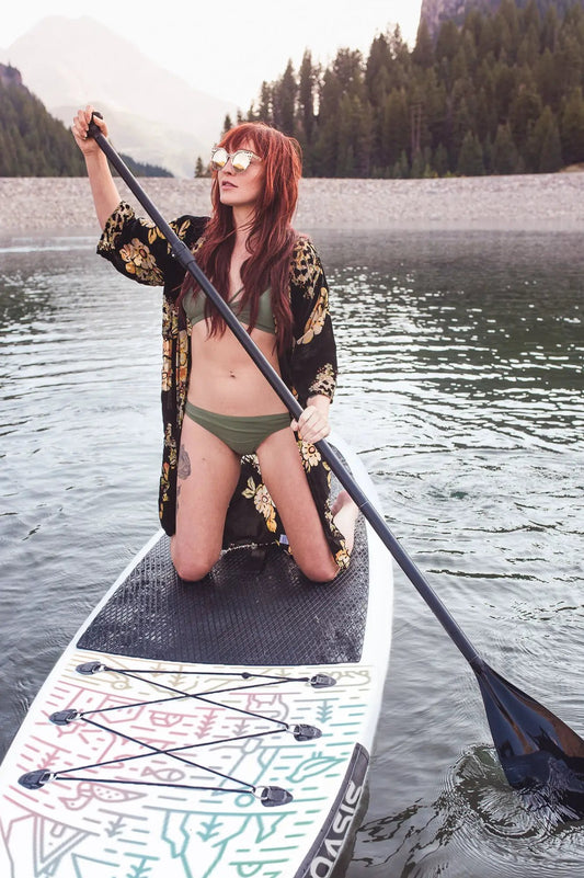 VidaGlide Oasis Pack inflatable paddle board on a calm lake with a colorful patterned deck on Tampa Home & Garden Store