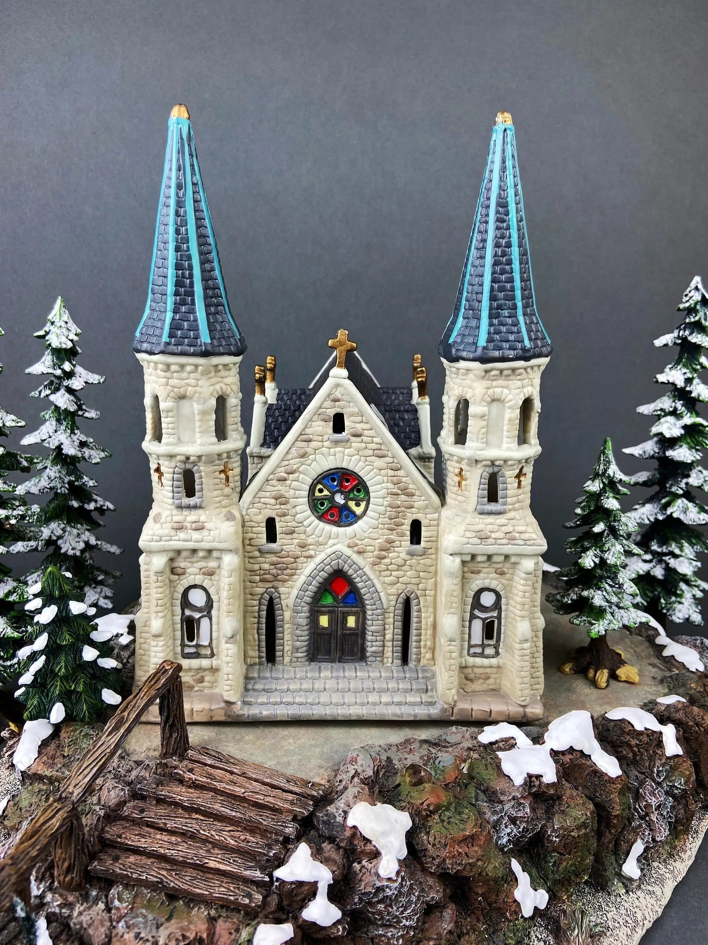 Village Accessories Lang and Wise castle with twin blue towers and snowy evergreens on Tampa Home & Garden Store