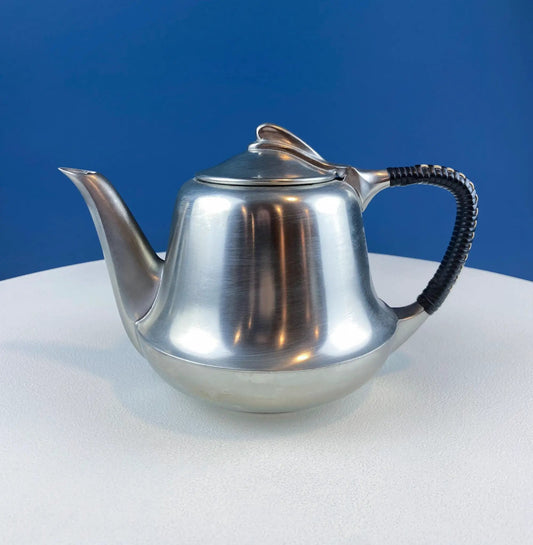 Pewter coffee pot with wrapped black handle and domed lid against blue backdrop on Tampa Home & Garden Store