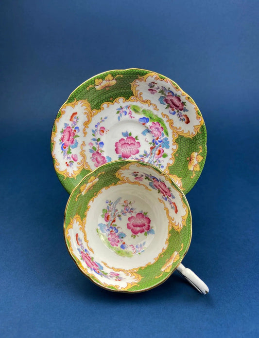 Vintage teacups and saucers stacked in green and pink floral pattern with gold scroll trim on Tampa Home & Garden Store