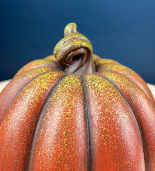 Vintage ceramic pumpkin with orange-red ridged surface, yellow speckled finish, and green stem on Tampa Home & Garden Store