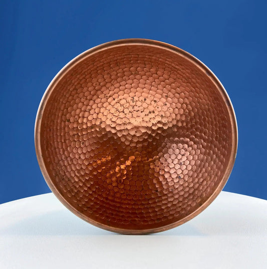 Vintage copper hand-pounded bowl with hammered interior against blue sky on Tampa Home & Garden Store
