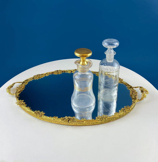 Vintage gold brass vanity tray with ornate edge and two glass decanters on mirrored surface on Tampa Home & Garden Store
