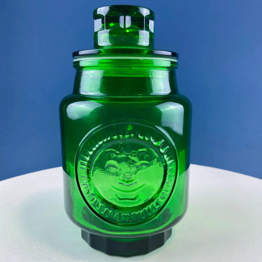 Vintage green glass storage canister with lid, cookie jar style, embossed seal detail on Tampa Home & Garden Store