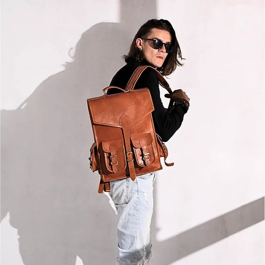 Vintage leather backpack with buckled front pockets in brown worn by a man in sunglasses on Tampa Home & Garden Store