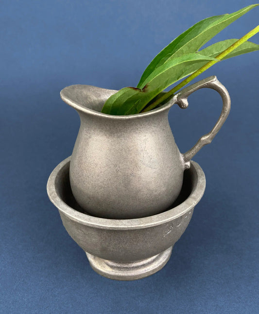 Vintage pewter creamer with a green leaf sprig, displayed on a matching stand on Tampa Home & Garden Store