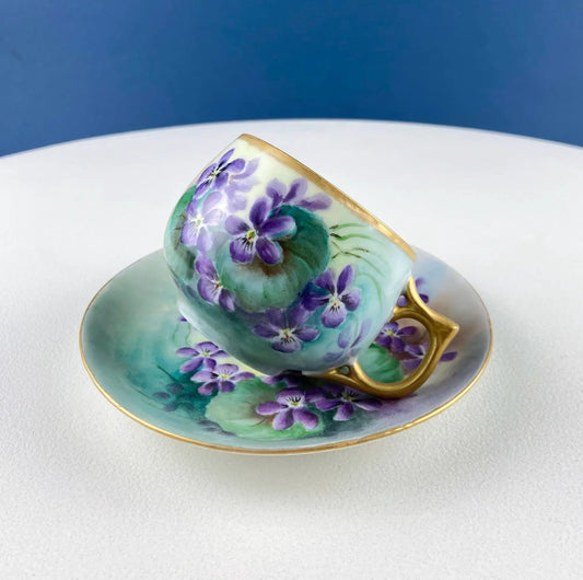 Vintage porcelain tea cup and saucer with purple violets, gold trim, turquoise tones on Tampa Home & Garden Store