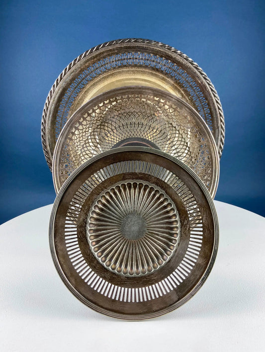 Vintage silver-plated serving platters set of four with filigree rims and sunburst centers on Tampa Home & Garden Store