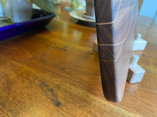 Walnut charcuterie board edge with cherry and maple banding, dark wood finish on Tampa Home & Garden Store