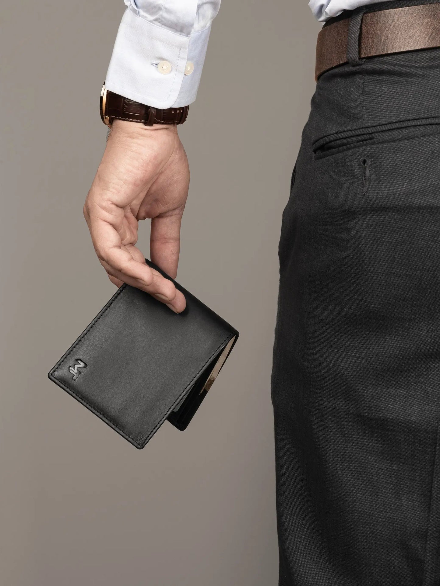 Wealth Ward black leather bi-fold wallet held in a man's hand on Tampa Home & Garden Store