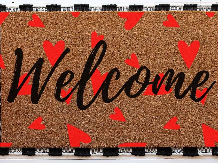 Door mat Welcome Heart DecoExchange® with black script on brown coir and red hearts on Tampa Home & Garden Store