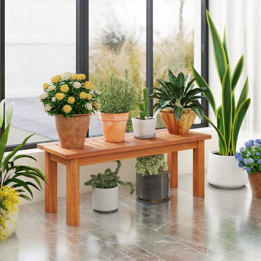 Wooden plant stand with several potted plants on a natural wood table on Tampa Home & Garden Store