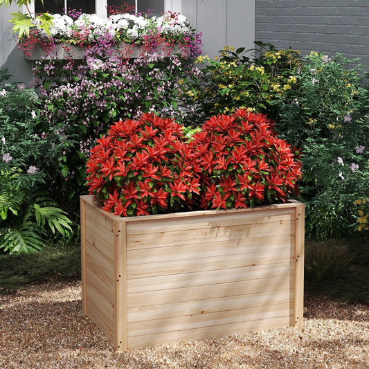 Wooden raised garden bed planter box with natural finish filled with red-leaf plants on Tampa Home & Garden Store