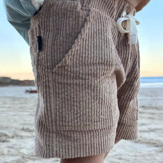 Yamba Tan Corduroy Shorts for Kids, relaxed fit with front pocket on a beach scene on Tampa Home & Garden Store