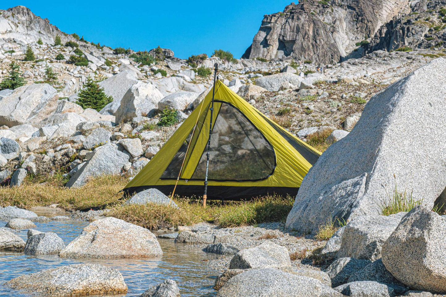 Trekker Pyramid 1-Person Backpacking Tent lime green with black floor pitched among alpine terrain on Tampa Home & Garden Store