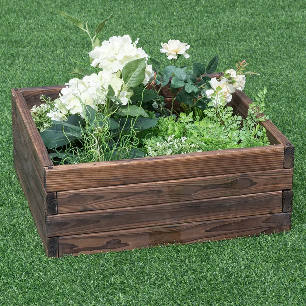 Square wooden raised garden bed planter filled with herbs and white flowers on green lawn on Tampa Home & Garden Store
