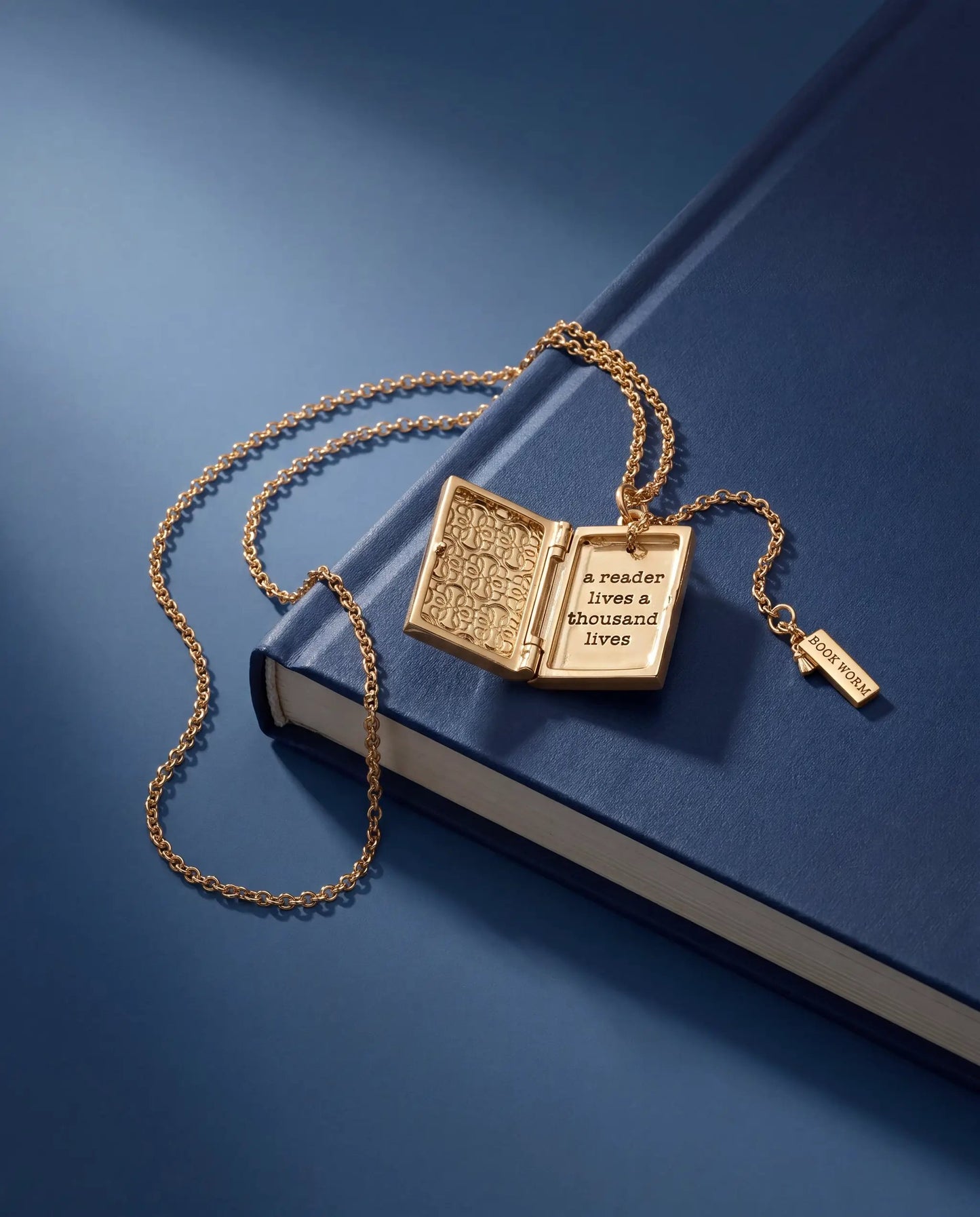 Gold book-locket necklace with open panels and a reader lives a thousand lives on Tampa Home & Garden Store