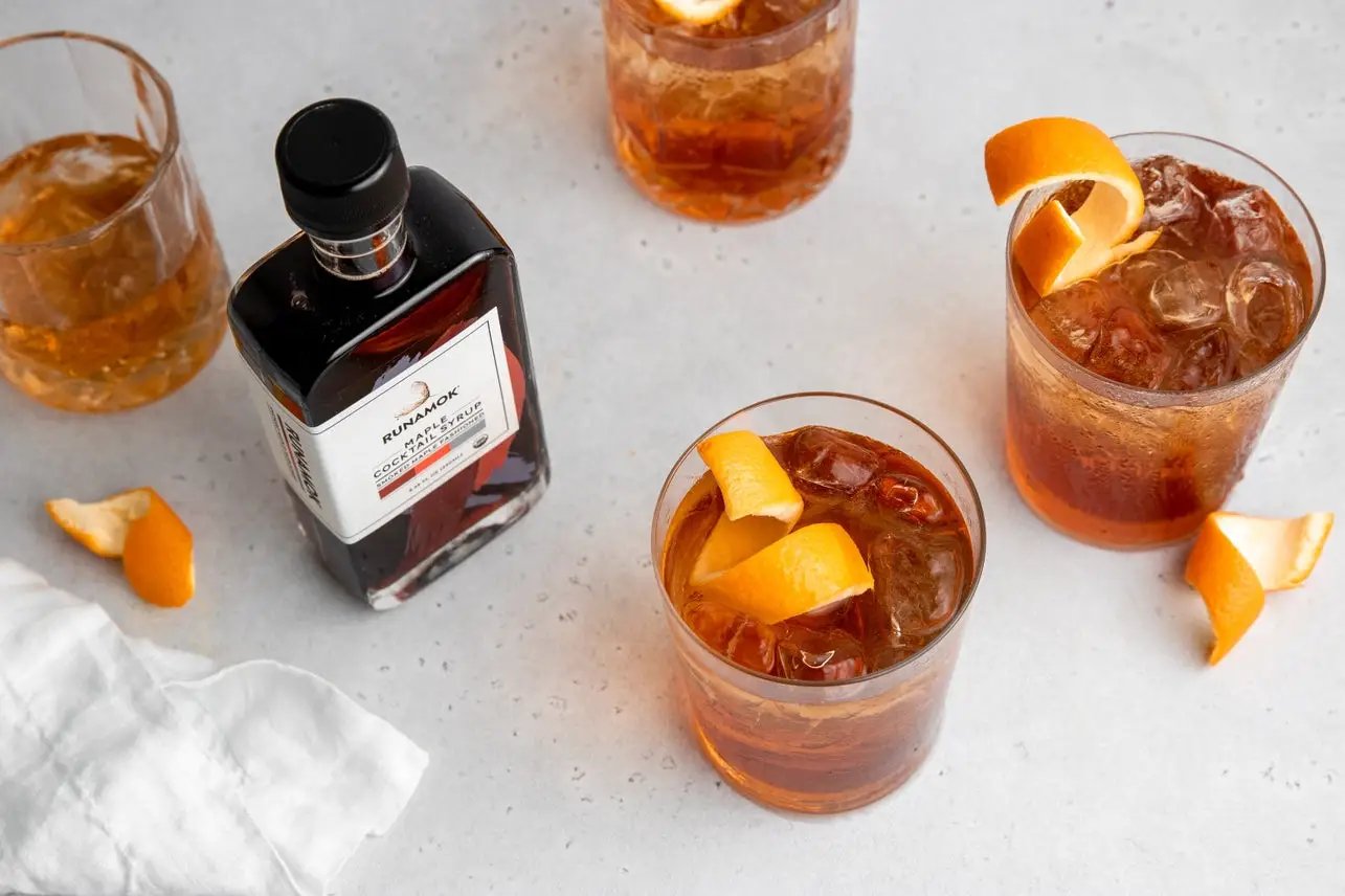 Runamok Smoked Maple Old Fashioned Cocktail Syrup bottle with orange twists and ice on Tampa Home & Garden Store