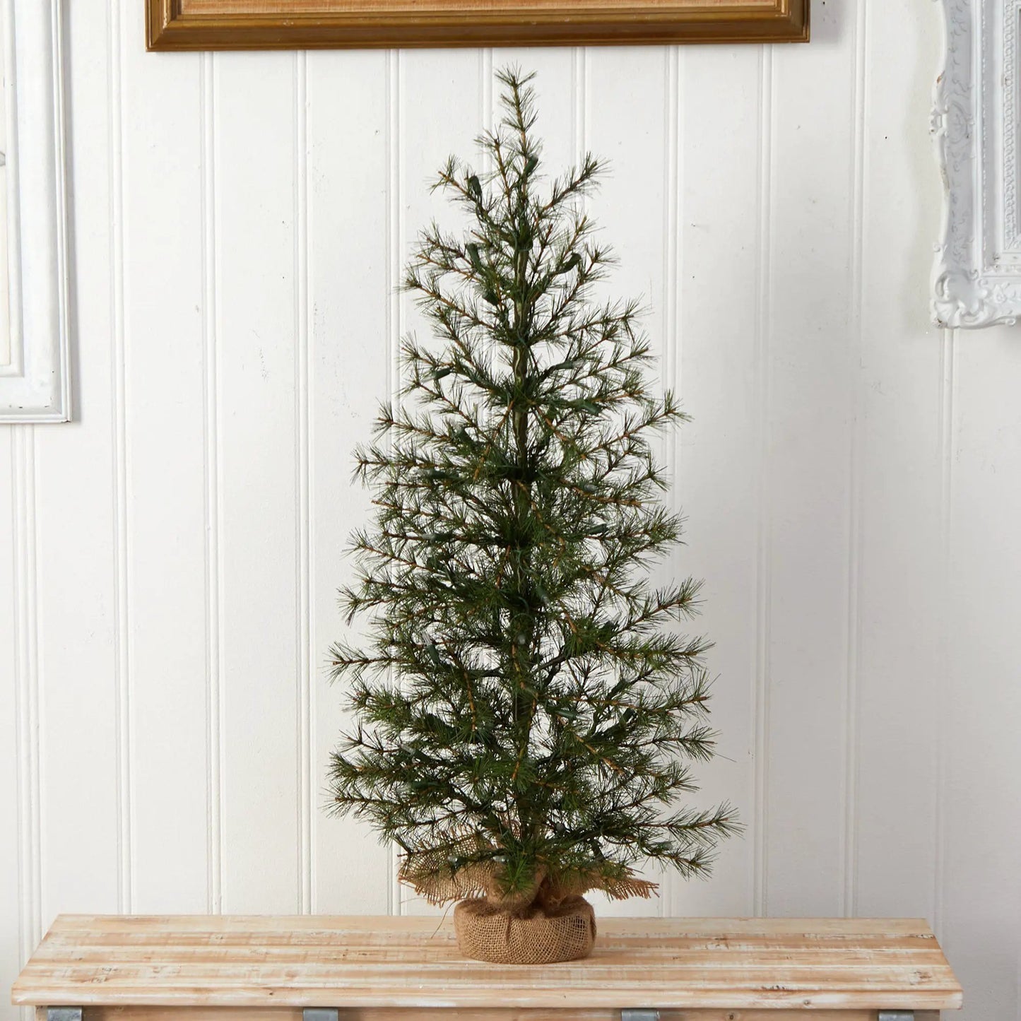3 ft artificial Christmas tree with burlap base pot and dark green needles on a wooden table on Tampa Home & Garden Store