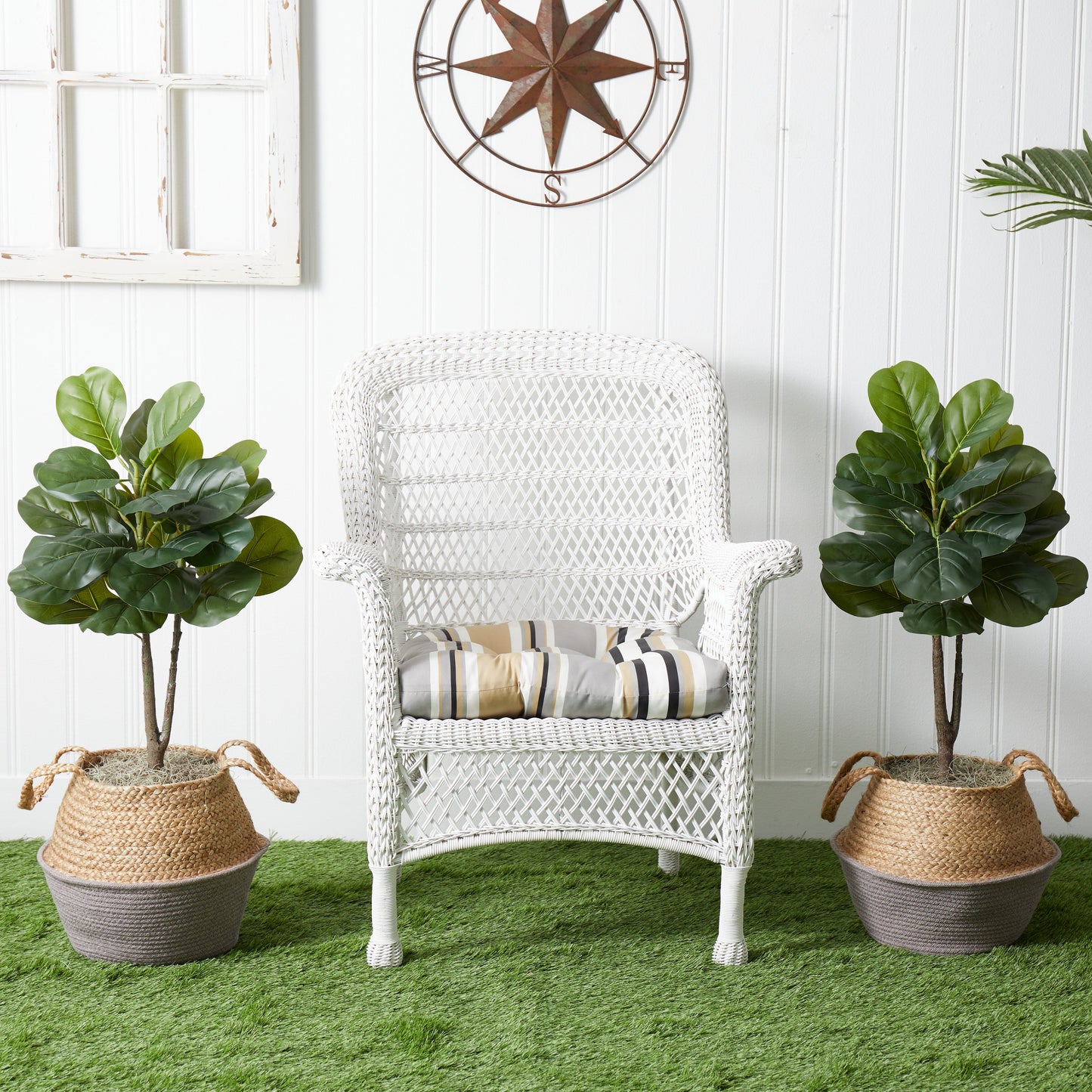 Two artificial fiddle leaf fig trees in woven planters flanking a white wicker chair on Tampa Home & Garden Store