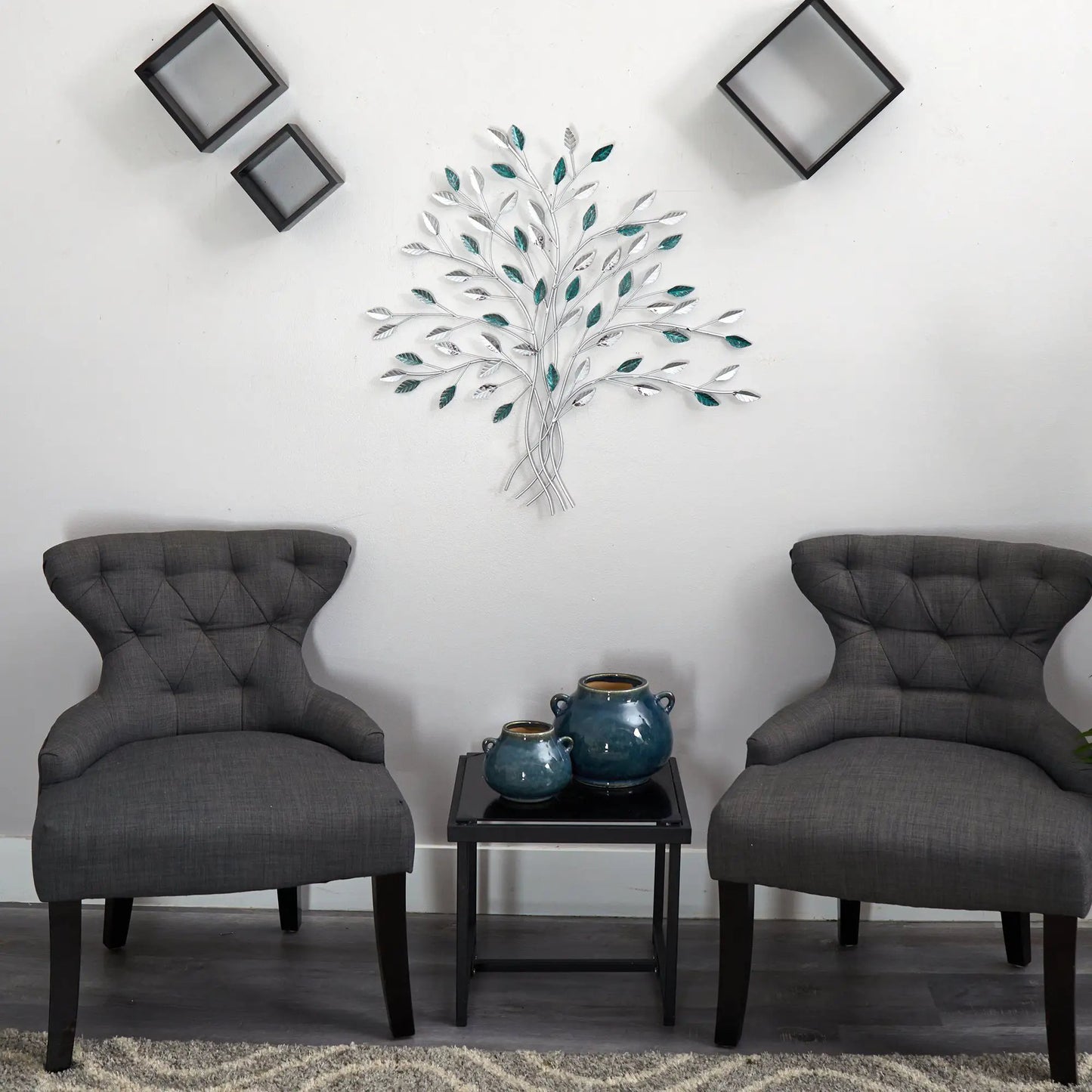 Hand-painted metal Tree of Life wall art with teal leaves and silver branches on white wall on Tampa Home & Garden Store
