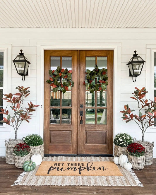 Two 6 ft Magnolia artificial trees by Nearly Natural with green and red leaves flank door on Tampa Home & Garden Store