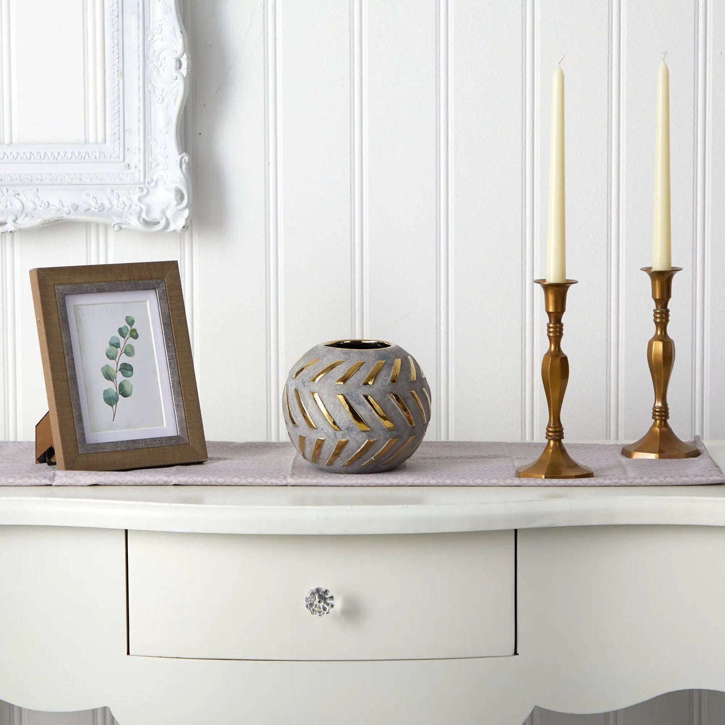 Regal round gray stoneware vase with gold accents beside two gold candlesticks on shelf on Tampa Home & Garden Store