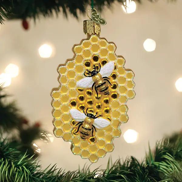 Honeycomb glass ornament with gold honeycomb pattern and bees, hanging from a green ribbon on Tampa Home & Garden Store