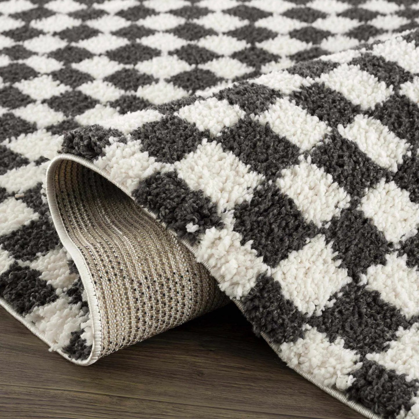 Kieu black and white checkered shag rug by Boutique Rugs showing rolled edge on wood floor on Tampa Home & Garden Store