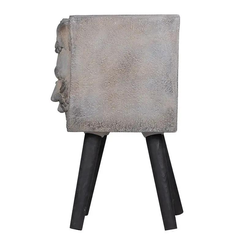 Gray square planter with Greek god relief on the side, supported by black tapered legs on Tampa Home & Garden Store