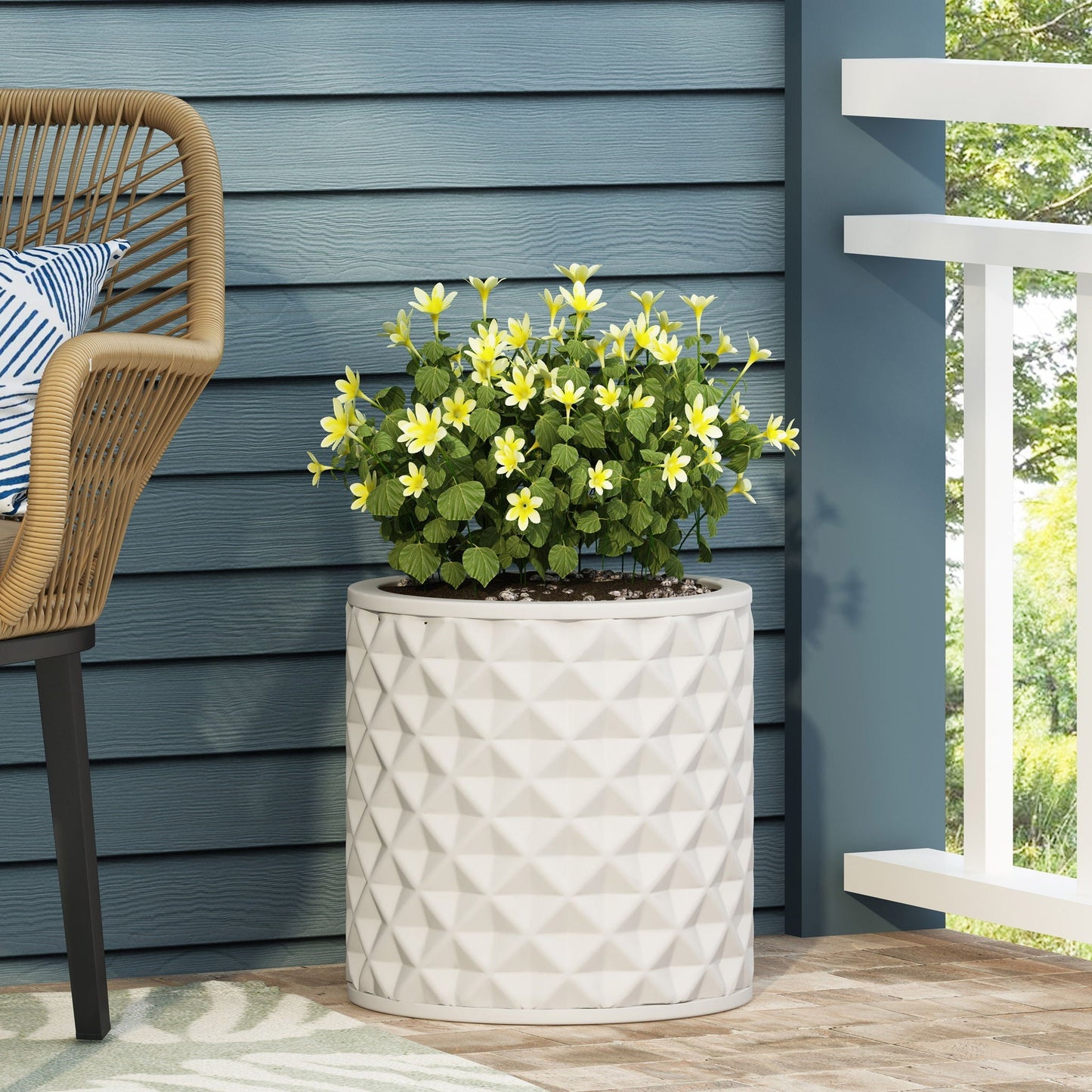 Antique white ceramic planter with geometric pattern, yellow flowers on blue siding on Tampa Home & Garden Store